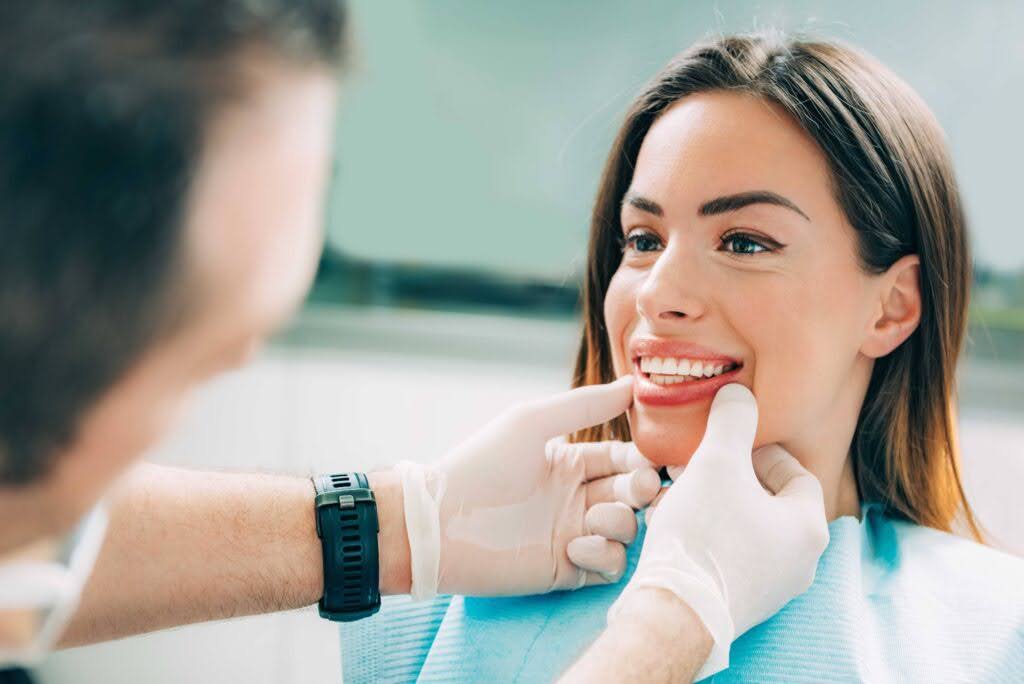 Young smiling woman with beautifiul teeth, having a dental inspection
