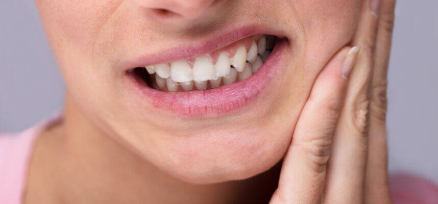 A woman has impacted wisdom tooth pain.