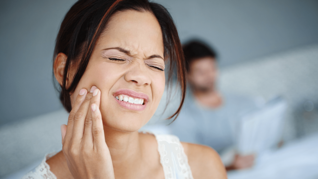 A girl is having pain in her gums due to a gum infection and swollen gums.