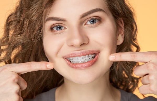 A beautiful girl showing her adult braces for teeth.
